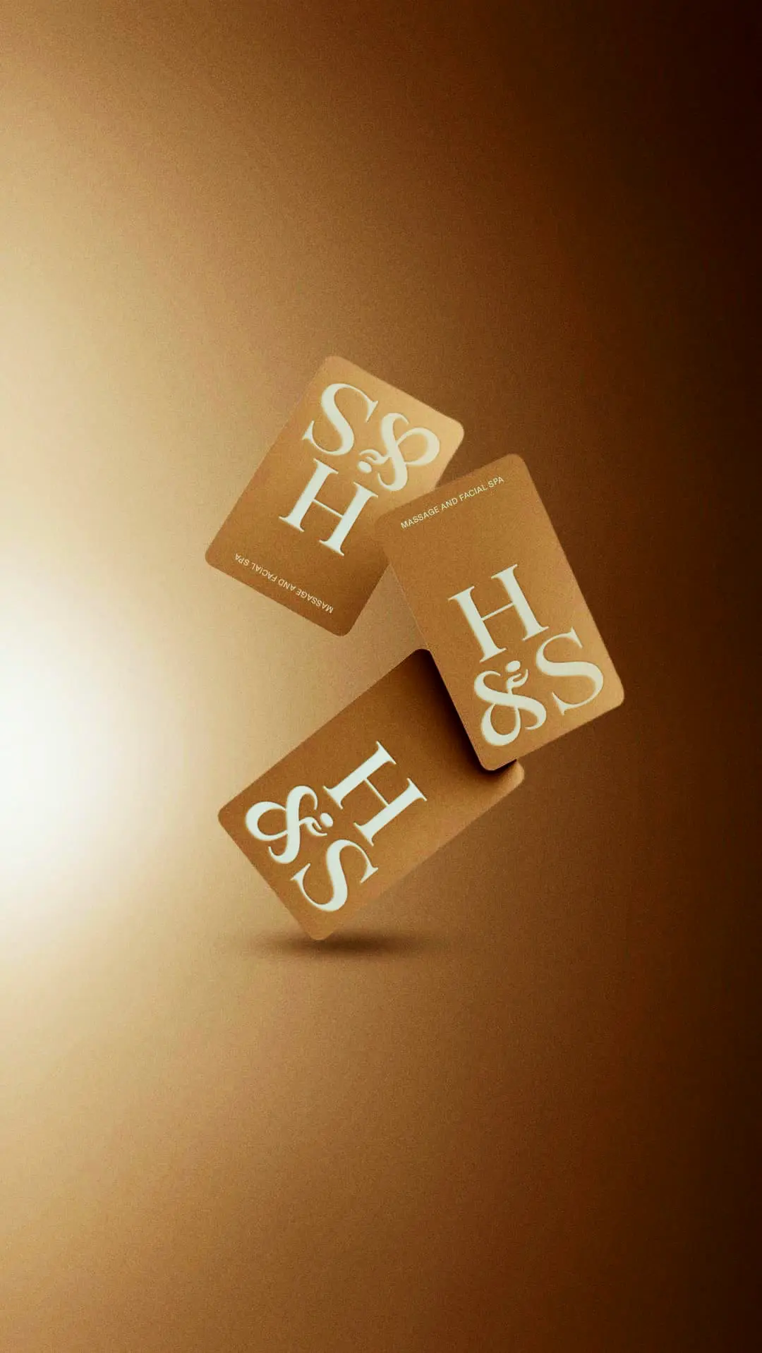 Three copper Hand & Stone gift cards with the H&S monogram