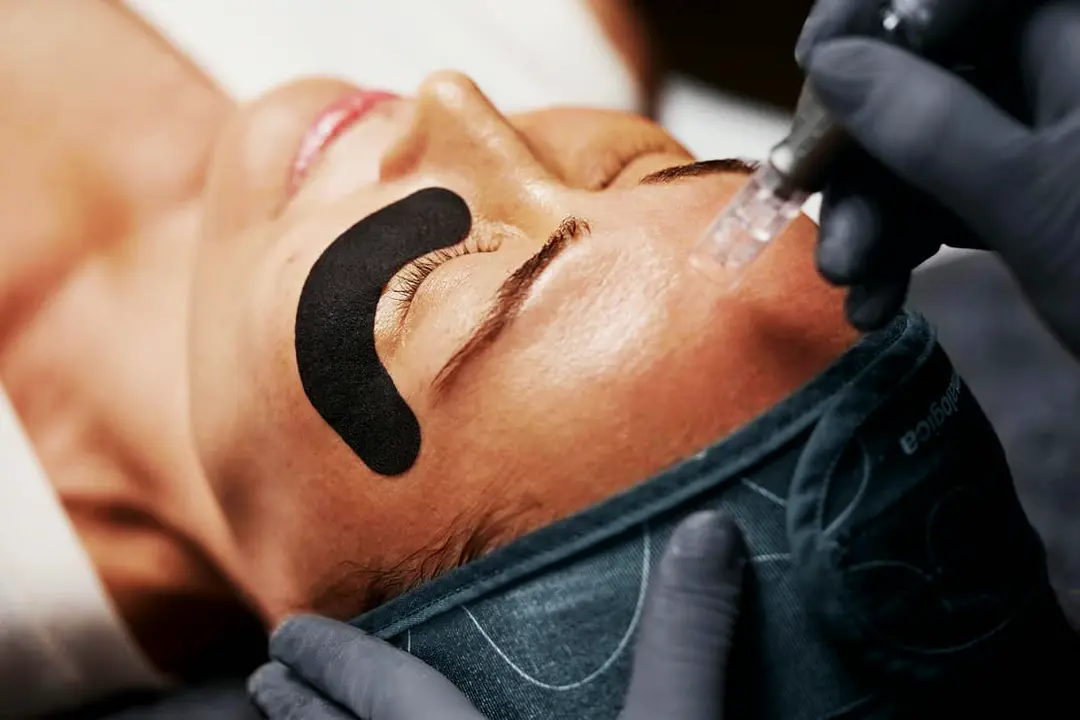 Gloved hands performing a LuminFusion facial treatment
