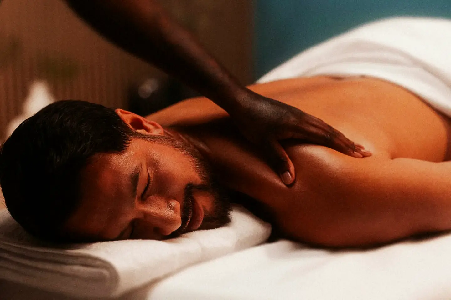 A guest lying face down on a massage table, eyes closed, during a back massage