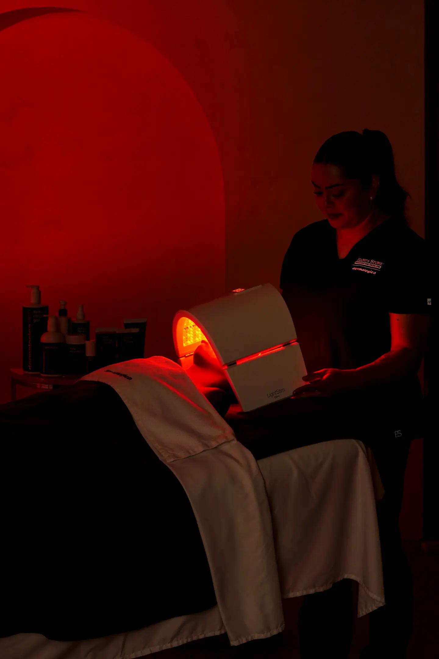 A Hand & Stone esthetician giving an LED light facial